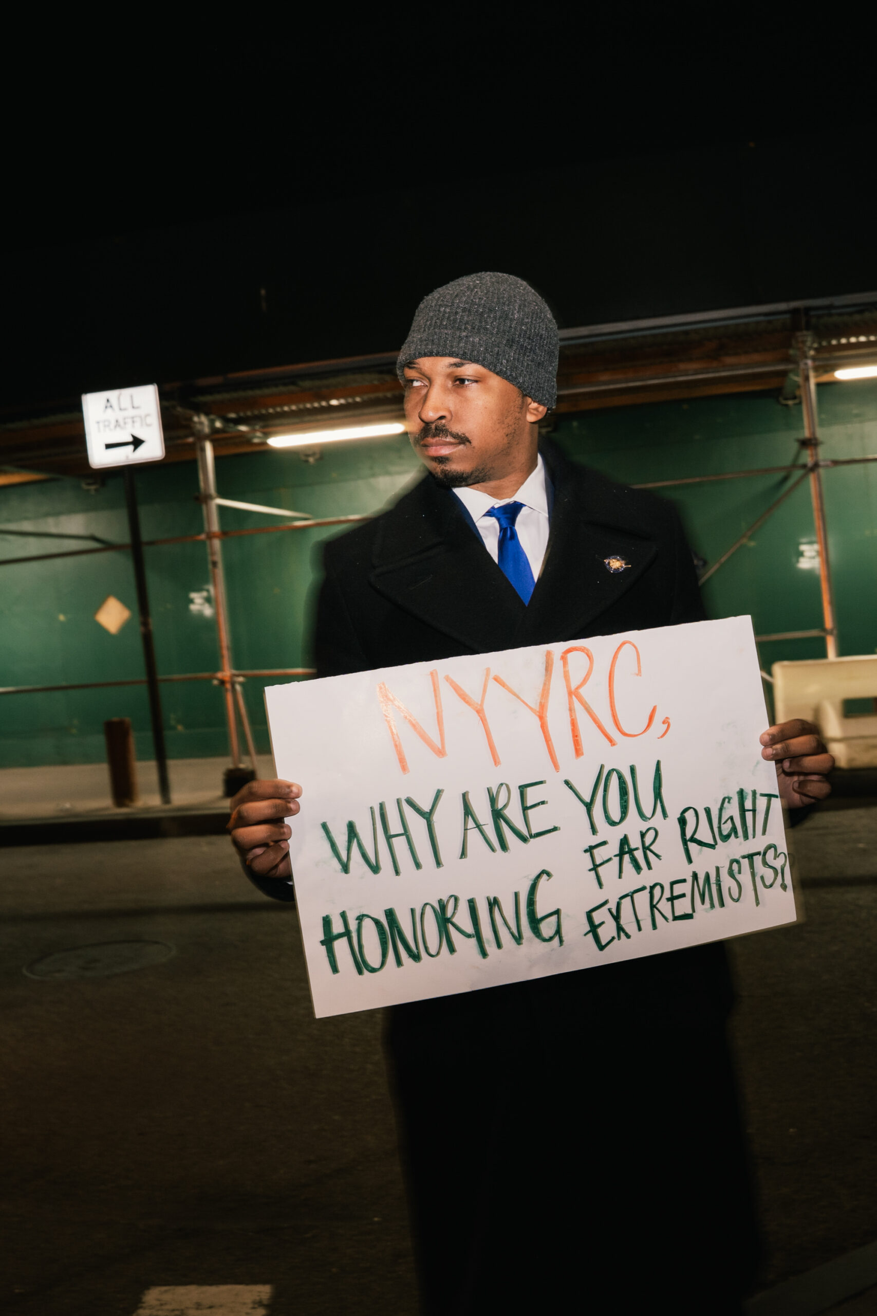 Assemblymember Jordan Wright stands during a protest outside the event.